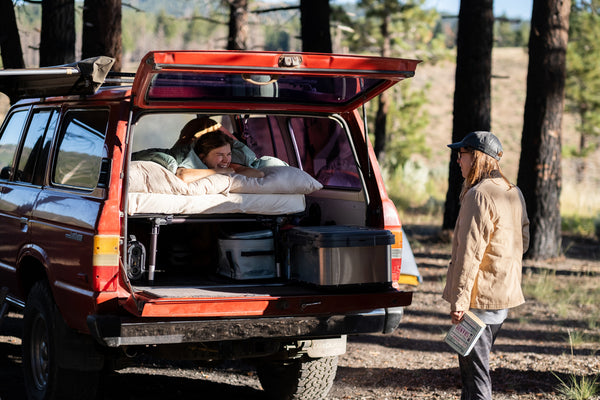 two friends talk while waking up camping