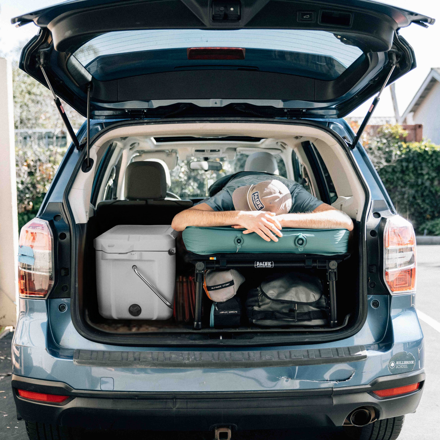 person lying on a sleeping platform in a trunk with luggage